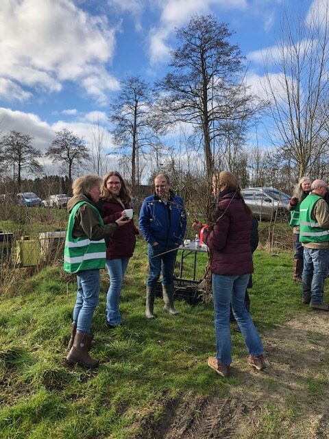 Vlnr Vrijwilligester Inger van der Wal in gesprek projectleidster buitengebied gemeente Westerkwartier Marijn Smit (met kop koffie in de hand), wethouder Bert Nederveen, afhalers met oogst vri